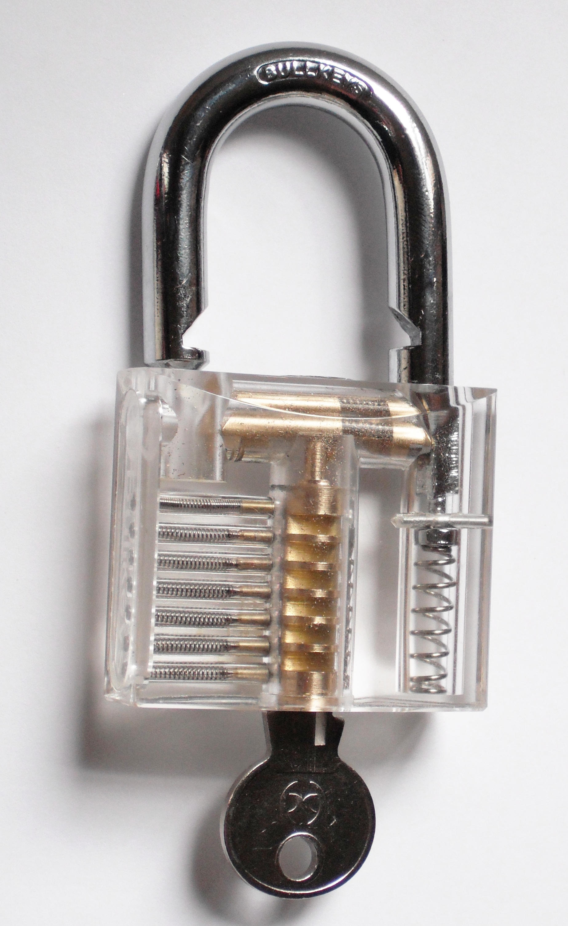 A transparent padlock photographed open with a key inserted, used as a visual metaphor for workflow token access.